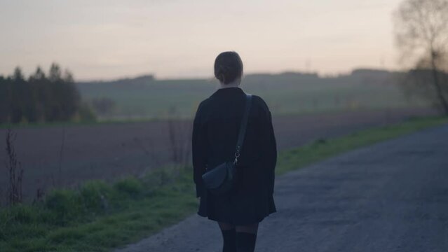 Sad young girl walking alone on the road. The loneliness of young people and the inability to find a relationship culminates in escaping into nature and closing off from society