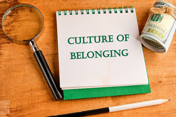 Culture of belonging symbol on a notebook with a magnifying glass and a roll of money on a papyrus...