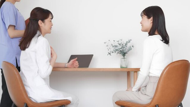 Doctor explaining to female patient undergoing examination. Interview at the hospital.