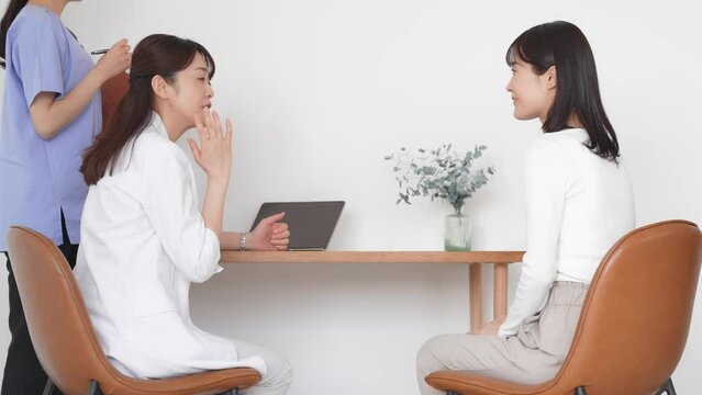 Doctor explaining to female patient undergoing examination. Interview at the hospital.