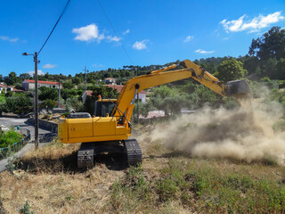 Retroescavadora a escavar alicerces para a construção de uma área residencial numa fazenda...