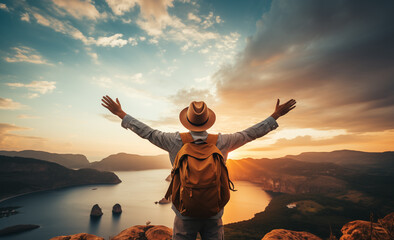 Thrilled hiker with backpack on the mountain top viewed from the back