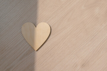 Photo of wooden heart design, showing empty space with sunlight.