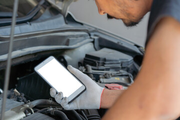 Technician man checking car engine and holding smartphone with isolate screen. Car service, repair,...