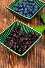 Fresh and dried berries on wooden table.