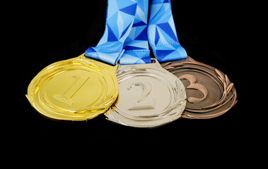 Gold, silver and bronze medal with ribbons isolated on black