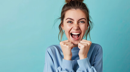 Portrait of an excited young  young woman isolated on blue background 