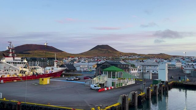 Early morning view of Vestmannaeyjar harbor with ships and colorful buildings, calm weather