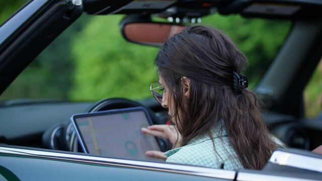Woman in car interacts with tablet GPS
