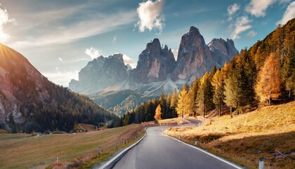 amazing mountain landscape at autumn sunny day scenic alpine scenery of dolomites alps wonderful view on mountain valley forest and asphalt road for majestic rocky peak travel on bike concept
