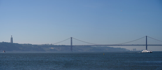 Obraz premium Panoramic View of the 25 De Abril Bridge and Sanctuary of Christ the King in Lisbon, Portugal