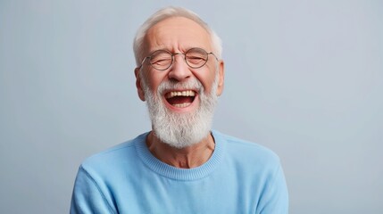 Portrait of old man wearing a blue sweater and glasses. laughing old man whit a beard, in glasses, happy against gray background.