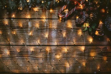 Wooden background with festive ornaments and golden Christmas lights