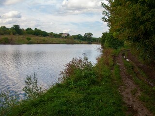 Beautiful shot of a lake surrounded by trees under a cloudy sky