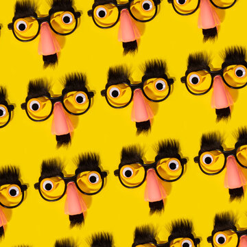 Pattern of funny disguise glasses with noses on yellow background