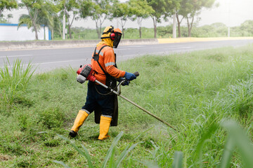 Landscaper Trimming Overgrown Grass with Machinery