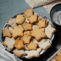 Making star-shaped shortbread cookies sprinkled with powdered sugar