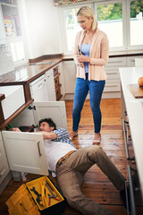 Plumber, working and woman watching stressed for pipe repairs, sink leaks and kitchen maintenance....