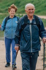 senior couple hiking outdoors in nature - 781171411