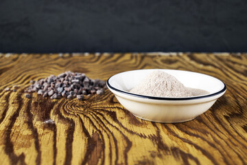 Black Kala namak salt on a plate and on a wooden table