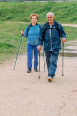 senior couple hiking outdoors in nature - 781171427