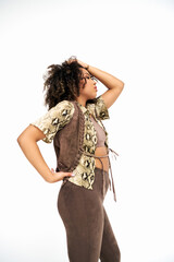 well dressed african american woman in attire with animalistic print on white backdrop looking away - 781171811
