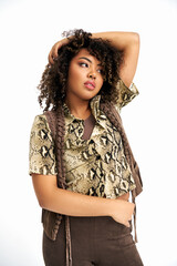 polished chic african american woman with curly hair posing on white backdrop and looking away - 781172217