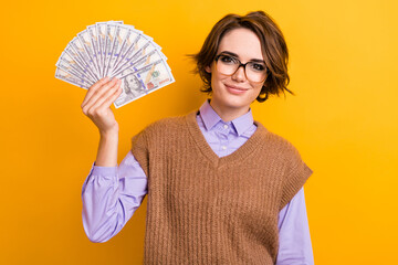 Photo of good mood girl with bob hairdo dressed knitwear waistcoat in glasses holding dollars in...