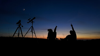 People enjoying watching and stargazing with astronomy telescopes outdoors in nature, observing planets, Moon and other celestial objects.