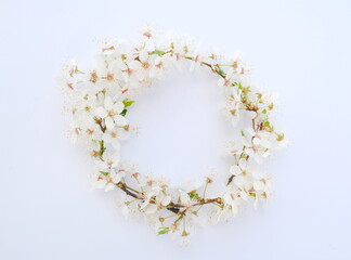 Wreath, frame of white tree flowers on a white background. Background, space for text, top view, copy.