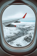 Fototapeta premium Winter landscape view with the flight wing from an airplane through window seat