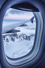 Fototapeta premium Winter landscape view with the flight wing from an airplane through window seat