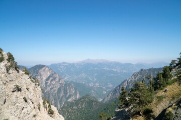Scenic mountains view with tree-covered slopes before the blue skyline