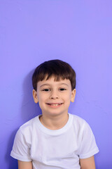 Little boy smiling on purple background
