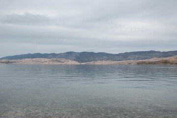 Scenic view of peaceful still water with mountains in the background