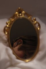 Obraz premium Vertical closeup shot of someone taking a mirror selfie of his earrings