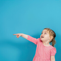 Little girl points her finger to the side on a blue background
