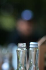 Shallow focus of transparent bottle necks on a blurry background