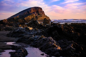Beautiful rocky shore of the sea during purple sunset