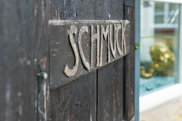 Side shot of schmuck text on gray old wooden dorr with blur background