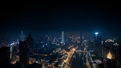 Aerial view of a modern city with bright colorful lights illuminating the darkness of the night
