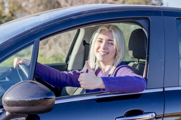 Woman giving thumbs up in car