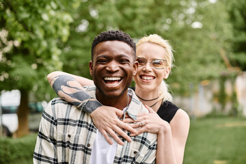 A joyful African American man holds a Caucasian woman in his arms, sharing a moment of love...