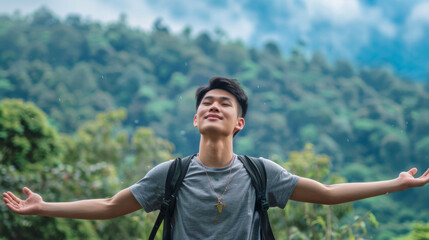 Fototapeta premium Portrait of a free happy Asian man with open arms enjoying life in meadows and nature background , young joyful chinese male with good mental health