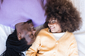 Top view of positive afro father and daughter looking at each other