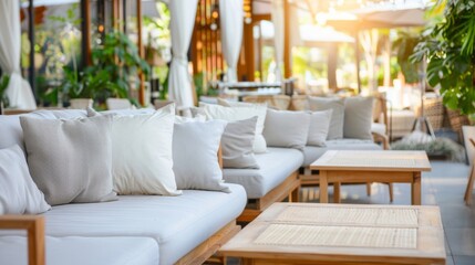 A lineup of white couches inside a sunlit cafe
