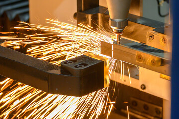 Close up scene the fiber laser cutting machine cut the square shape stainless steel tube with sparkling light.