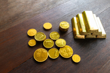 gold bar and a pile of coins on the table.