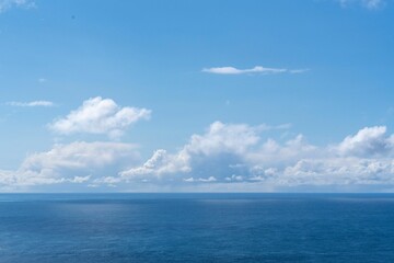 Naklejka na ściany i meble View of blue sea and clouds in a blue sky