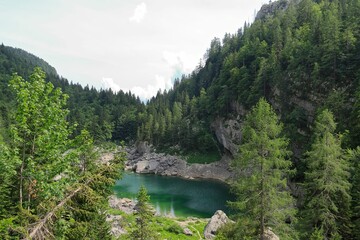 Fototapeta na wymiar Small lake surrounded by greenery in Triglav National Park, Slovenia